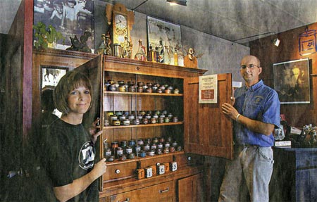 Kris Vrtiska (left) and her husband, Kim, display products in a refinished antique hutch in their retail gift store. Kim, who did the refinishing, has made other display cabinets.